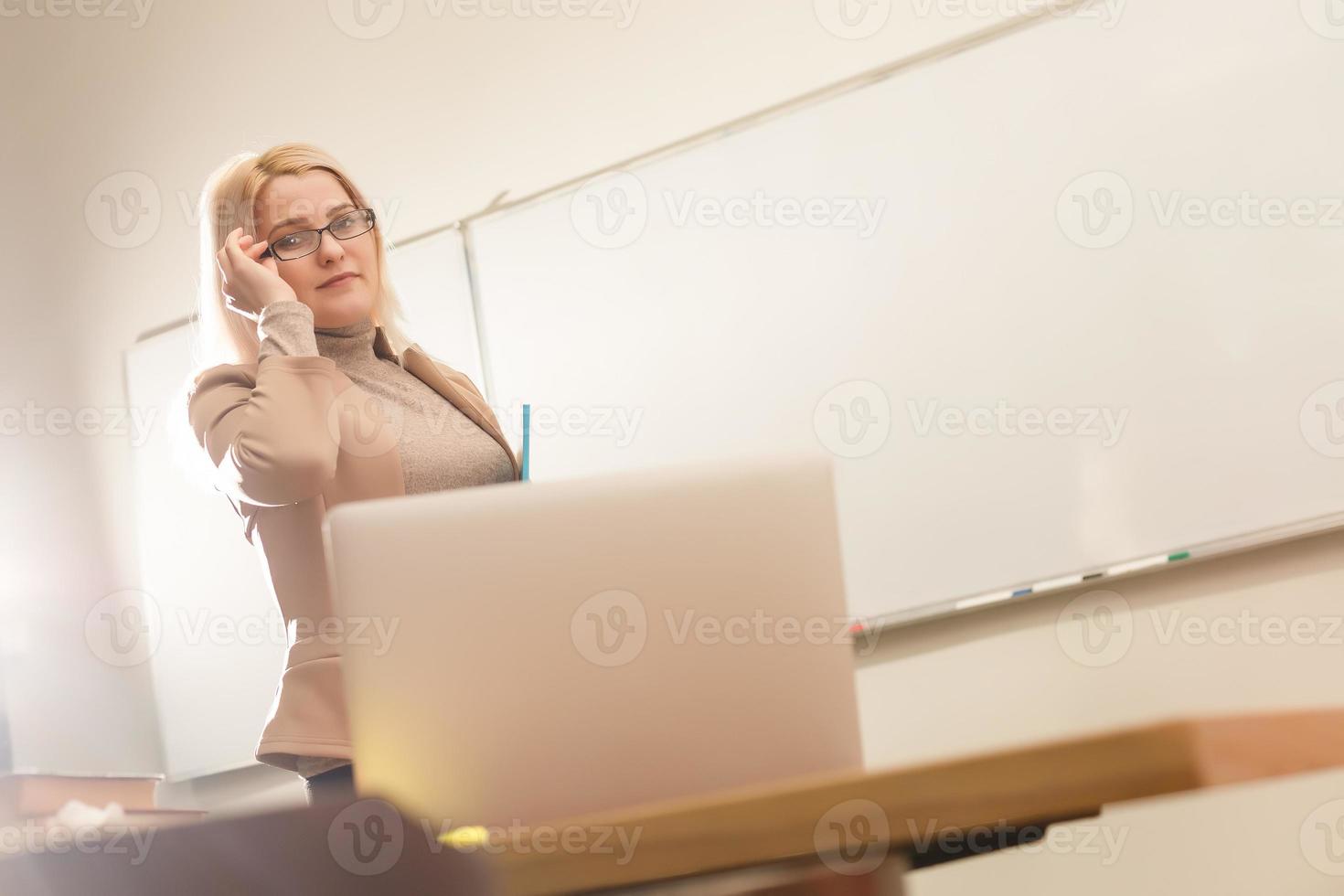 E-Learning concept with student holding his modern laptop computer, Tutor needs to be enthusiastic and needs to like his subject, Teacher drawing at classroom in school, photo