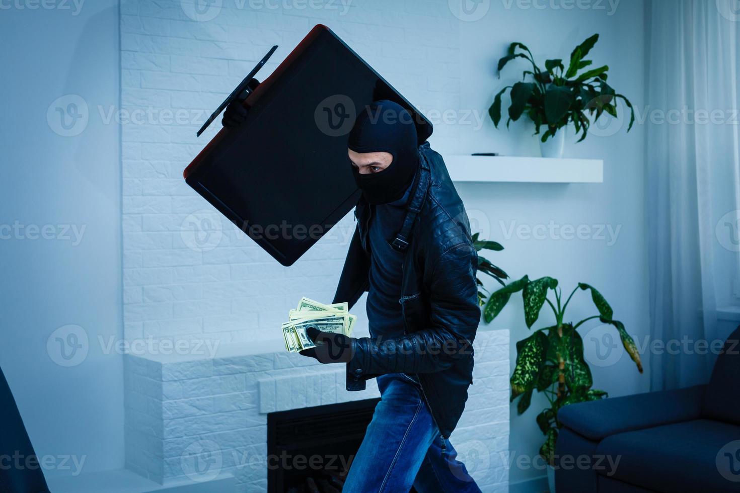 Man burglar stealing tv set from house photo