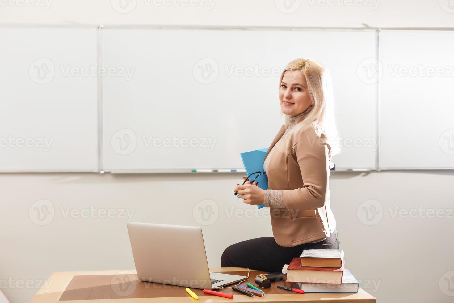 E-Learning concept with student holding his modern laptop computer, Tutor needs to be enthusiastic and needs to like his subject, Teacher drawing at classroom in school, photo