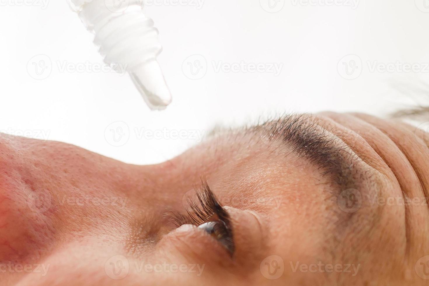 Close up of male face and eye drops photo