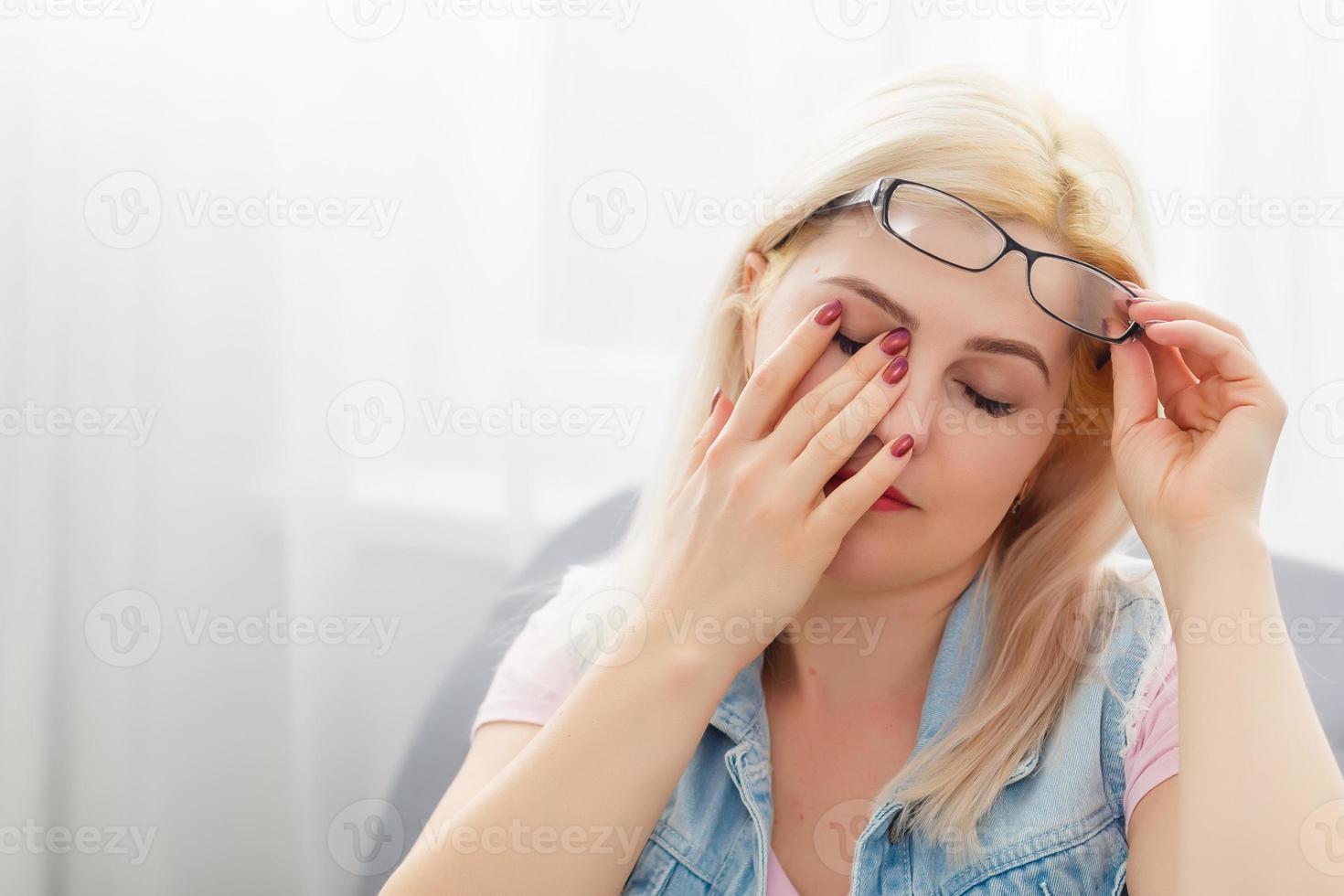 yawning woman sitting on sofa at home photo