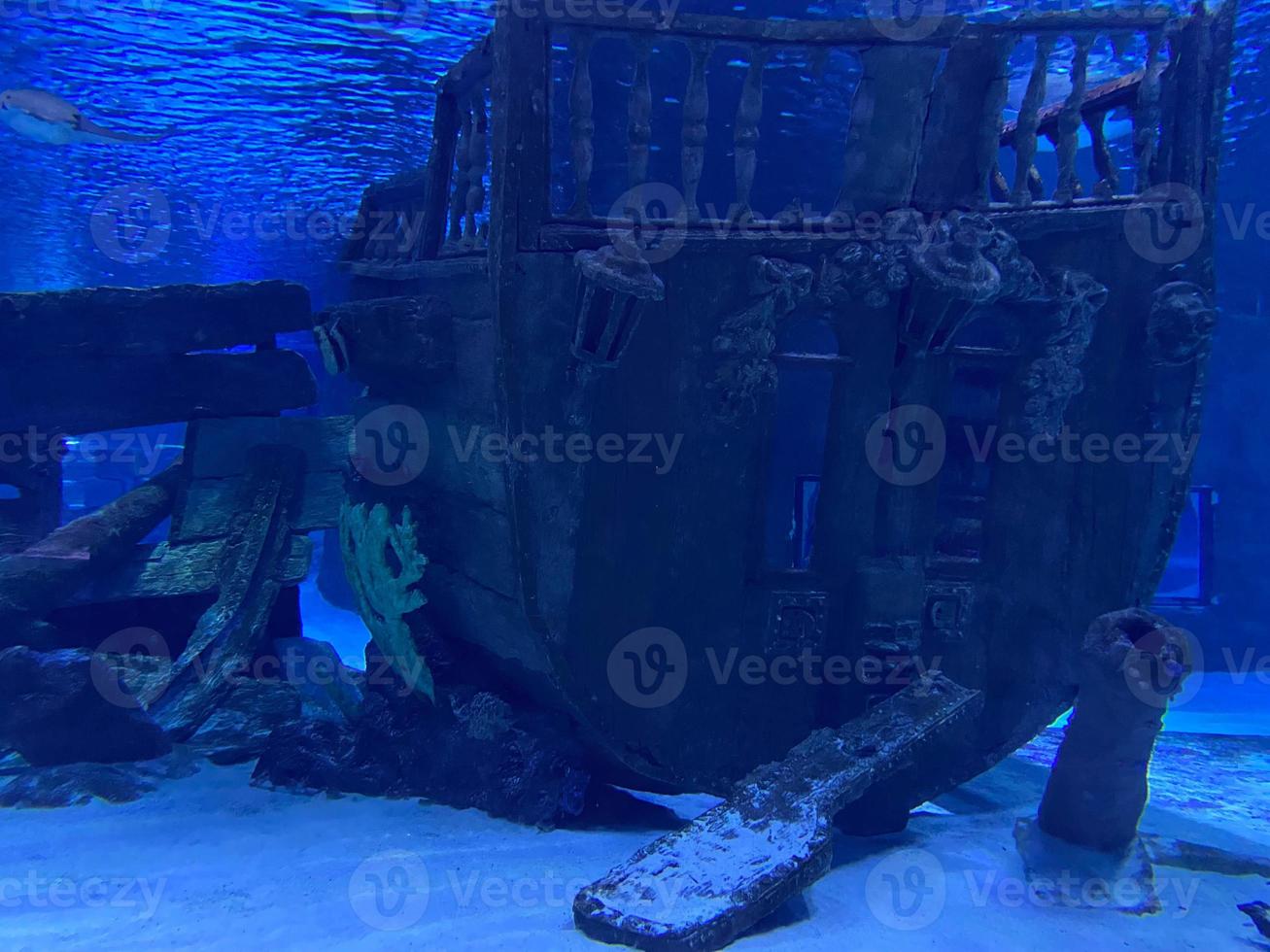 Underwater panorama of a scuba diver with a torch exploring a sunken shipwreck at the Maldives islands, Indian Ocean photo