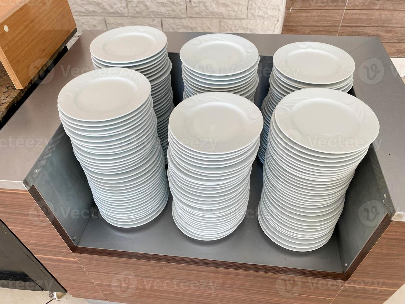 Many stacks of white ceramic plates clean washed in a cafe in the dining room in a cafe fast food restaurant photo