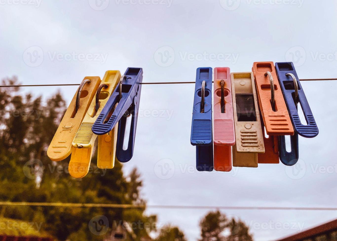 Clothespins for hanging clothes to dry hang on a thread under a canopy on the street. photo