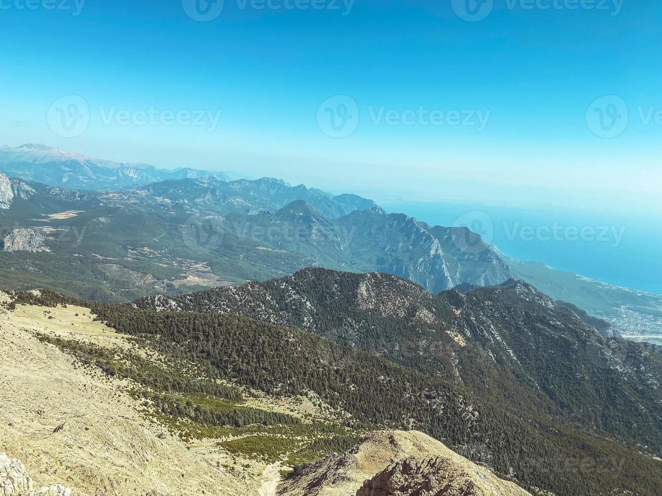 mountains in a hot, tropical country against a blue sky. green plants grow on the mountains. near the sea photo