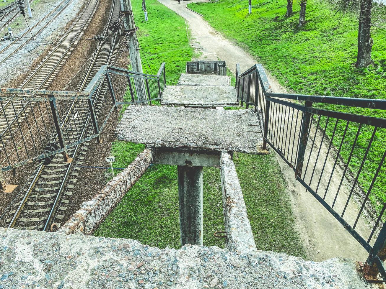 Old concrete railway bridge with broken steps. Rusty, broken staircase with fallen steps. Bad infrastructure photo