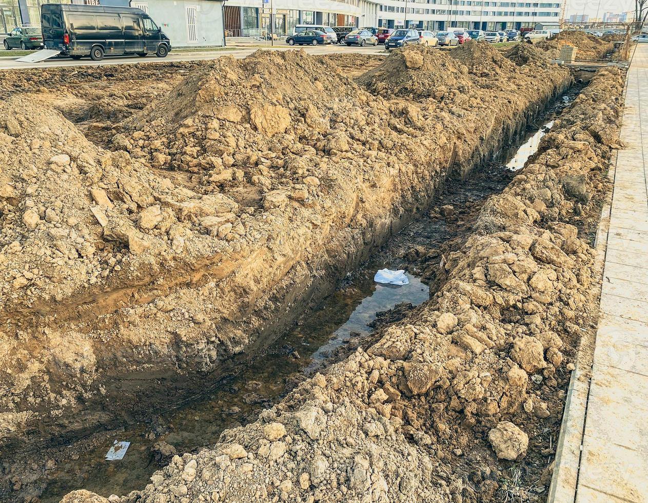 sandy ditch with communications. pipes are being laid in a new microdistrict of the city to bring communications to residential buildings photo