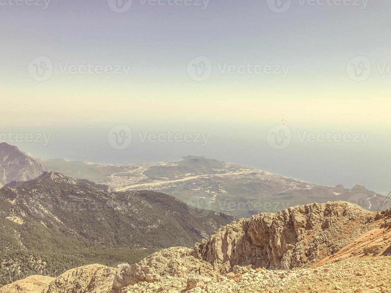 montañas contra el cielo azul. altiplanicie de piedras y arena. la hierba y los arbustos crecen en la montaña. ocio. rutas de senderismo en la montaña, viajes a países cálidos foto