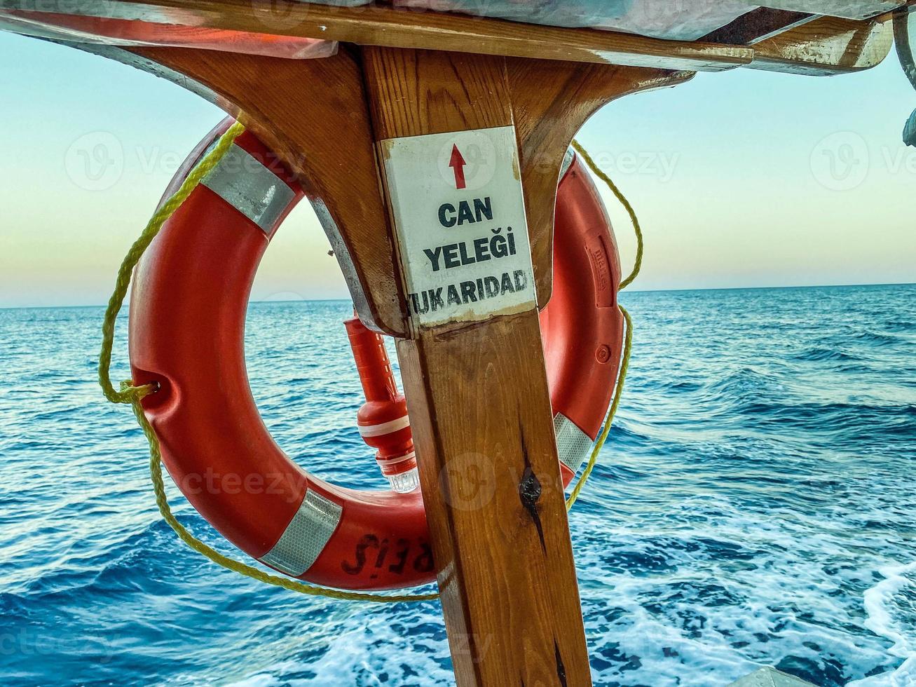 an orange lifebuoy attached to the deck of the ship. rubber protective equipment in case of human flooding. swimming underwater in the sea photo