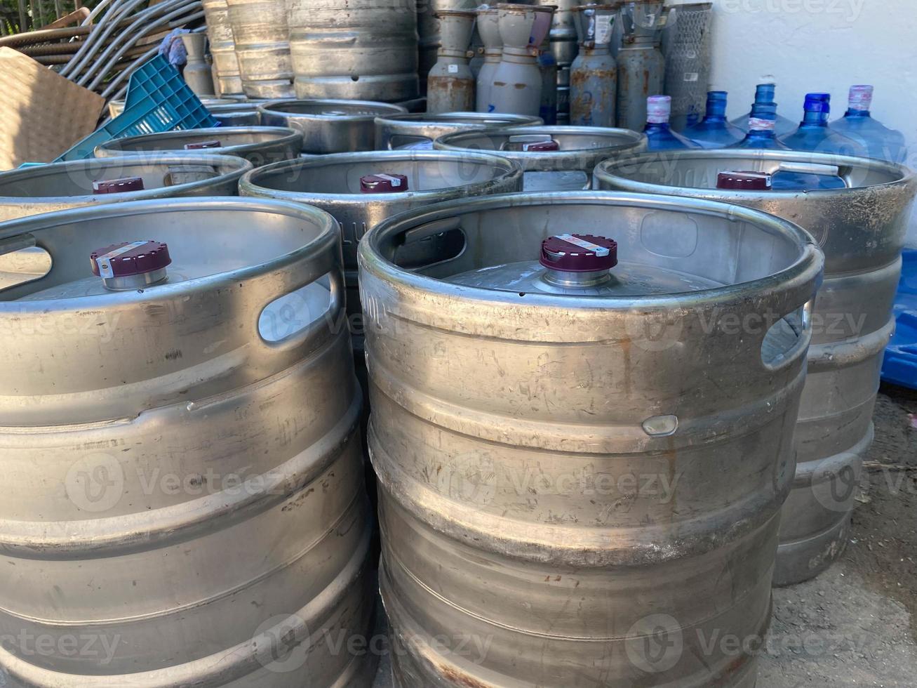 metal barrels at a construction site. large containers for liquid and bulk building materials. the barrels have convenient hand holders. screw cap at the top photo
