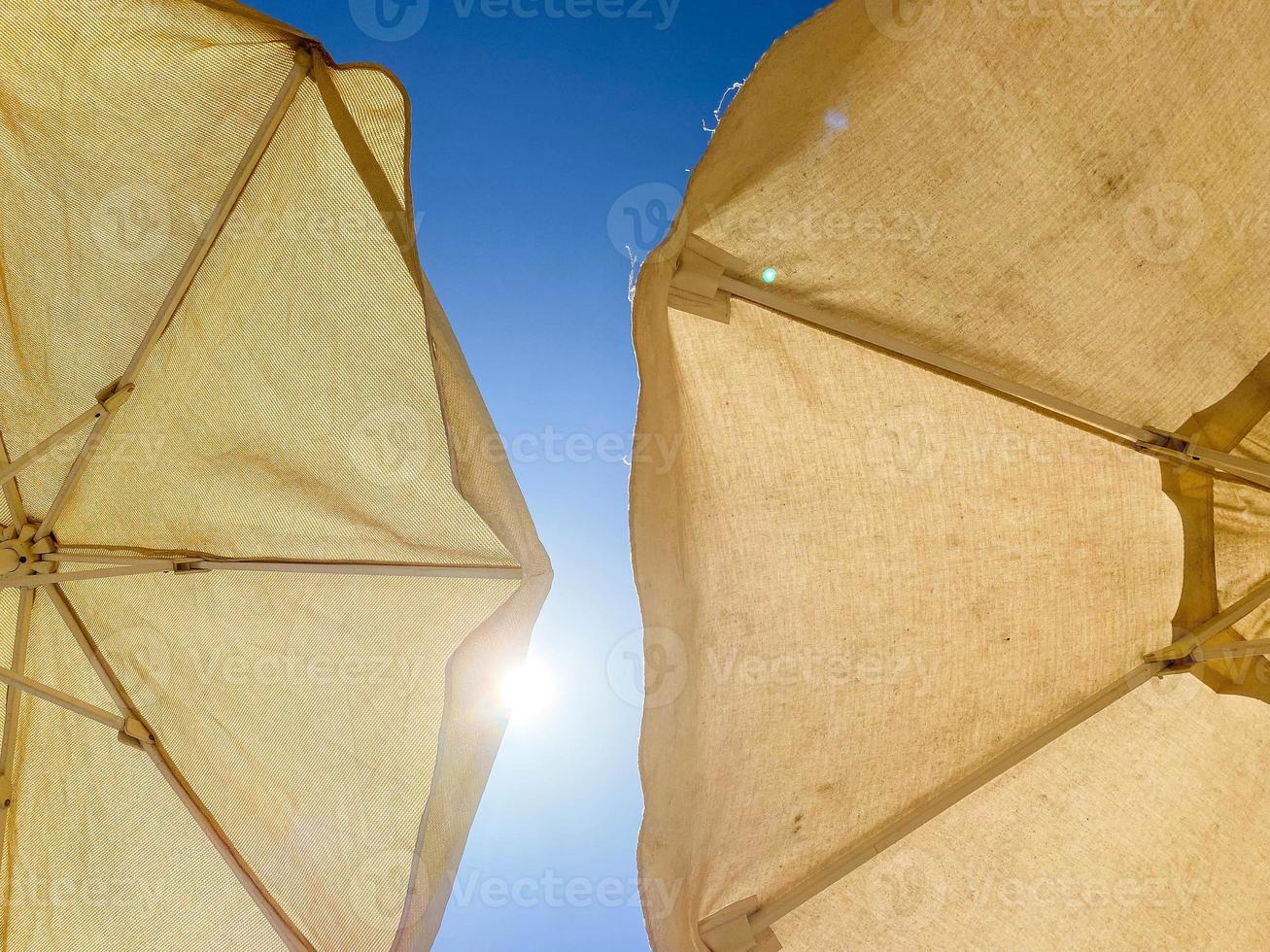 vacation at sea on the beach. high fabric umbrella to protect the body and face from the hot sun, creating artificial shade photo