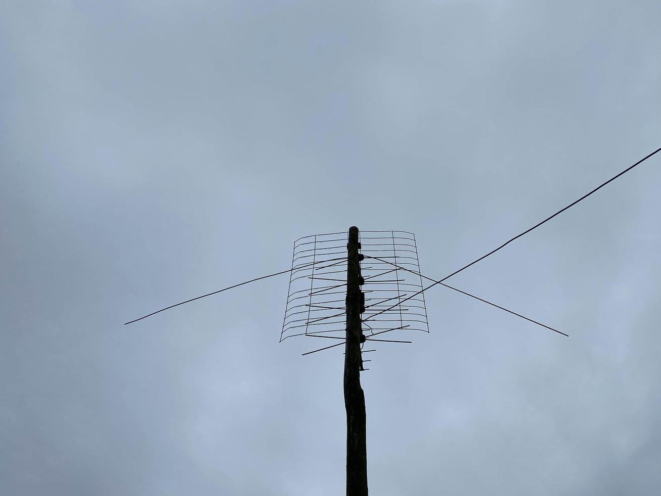 Old outdoor antenna for receiving a television signal against a bright blue sky photo