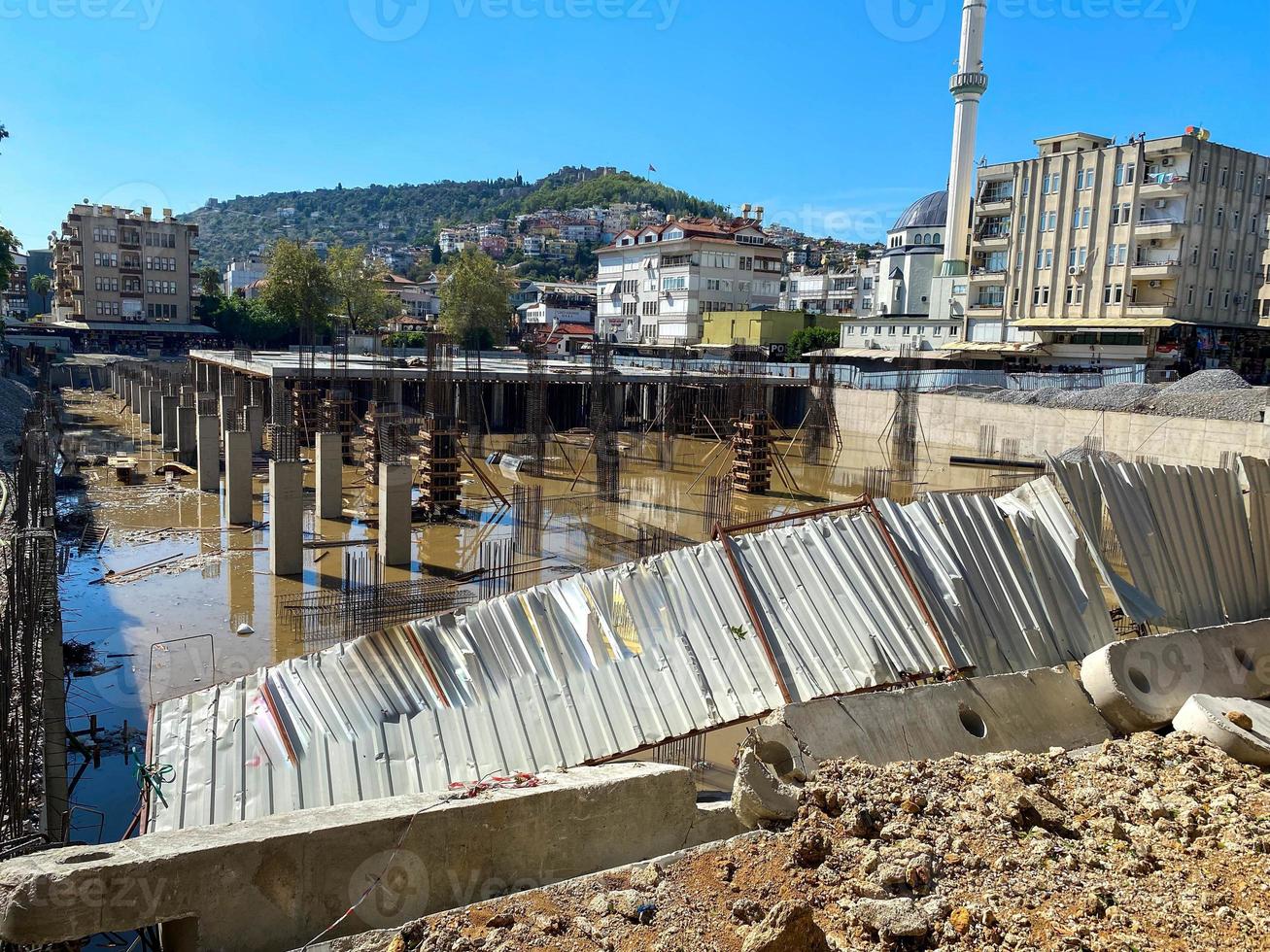 Construction of a monolithic-frame building, unfinished foundation with reinforced concrete columns at a construction site with a flooded pit photo