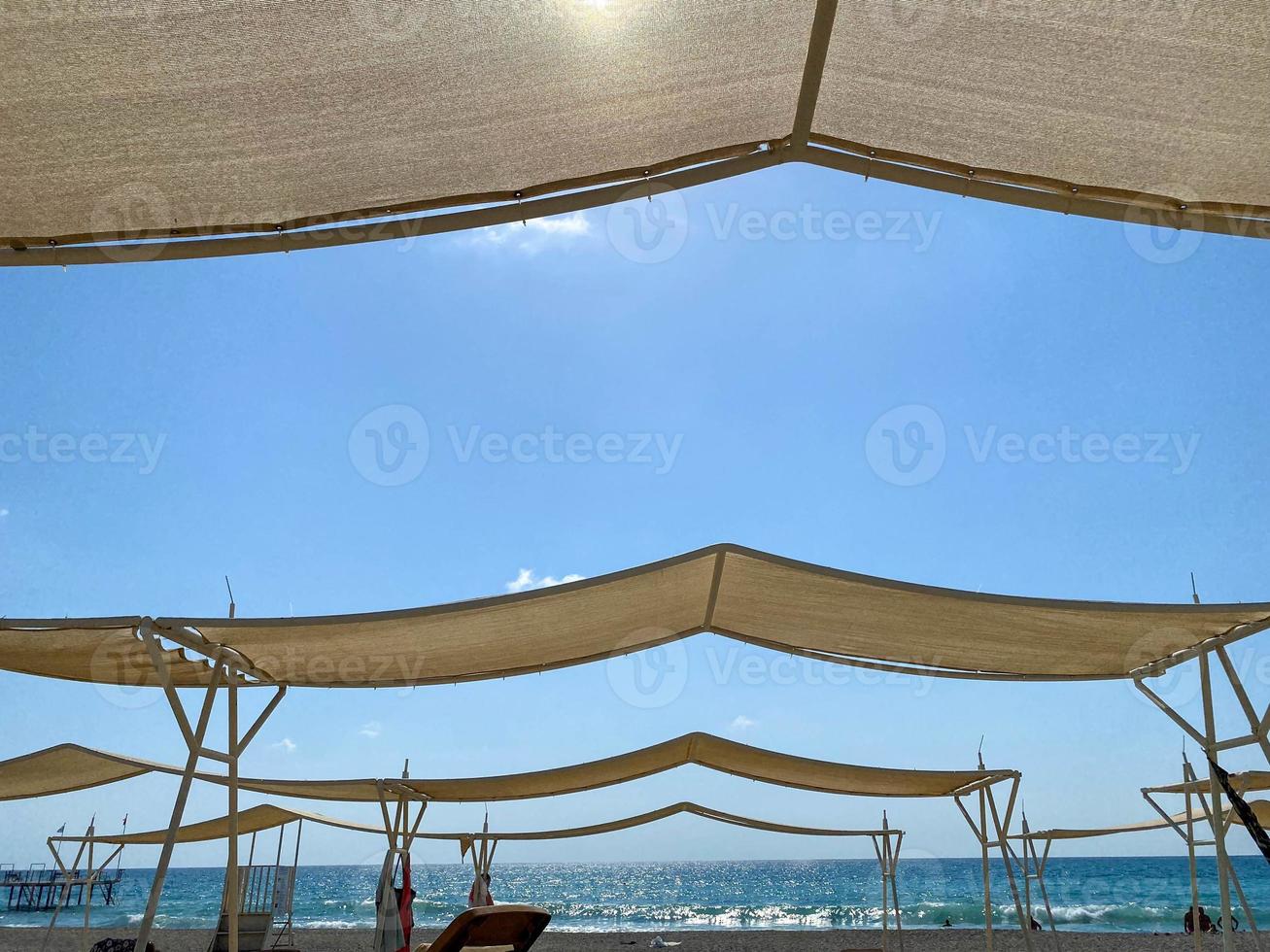 Canopy from the sun sun umbrellas against the background of the blue sky on the beach in the tourist warm tropical country paradise resort on vacation photo