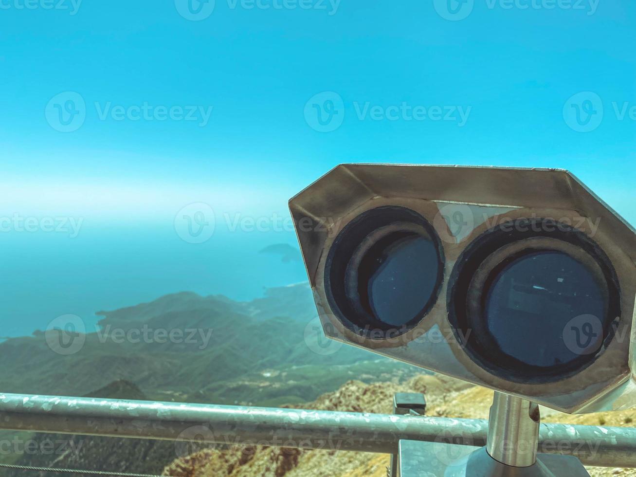 a viewing platform with binoculars with large black lenses against the background of a sunny blue sky. environment magnifier. panoramic binoculars for tourists photo