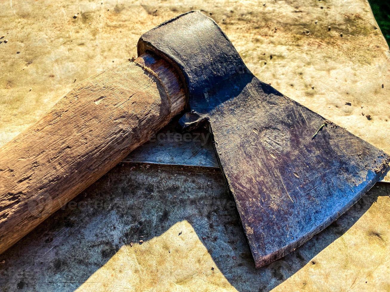 the ax lies on a metal bench. a tool for cutting wood, building a house, working with wood. metal ax with a handle made of natural material. cold weapon for combat photo