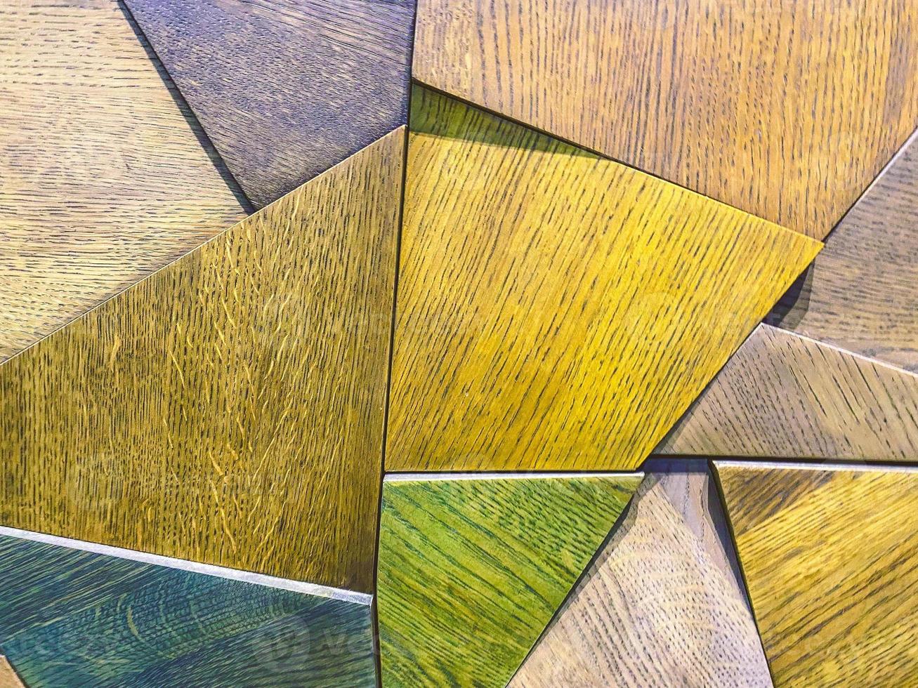 bright texture, background. Triangles made of wood are painted in different colors. panel on the wall. decorative elements in the interior photo