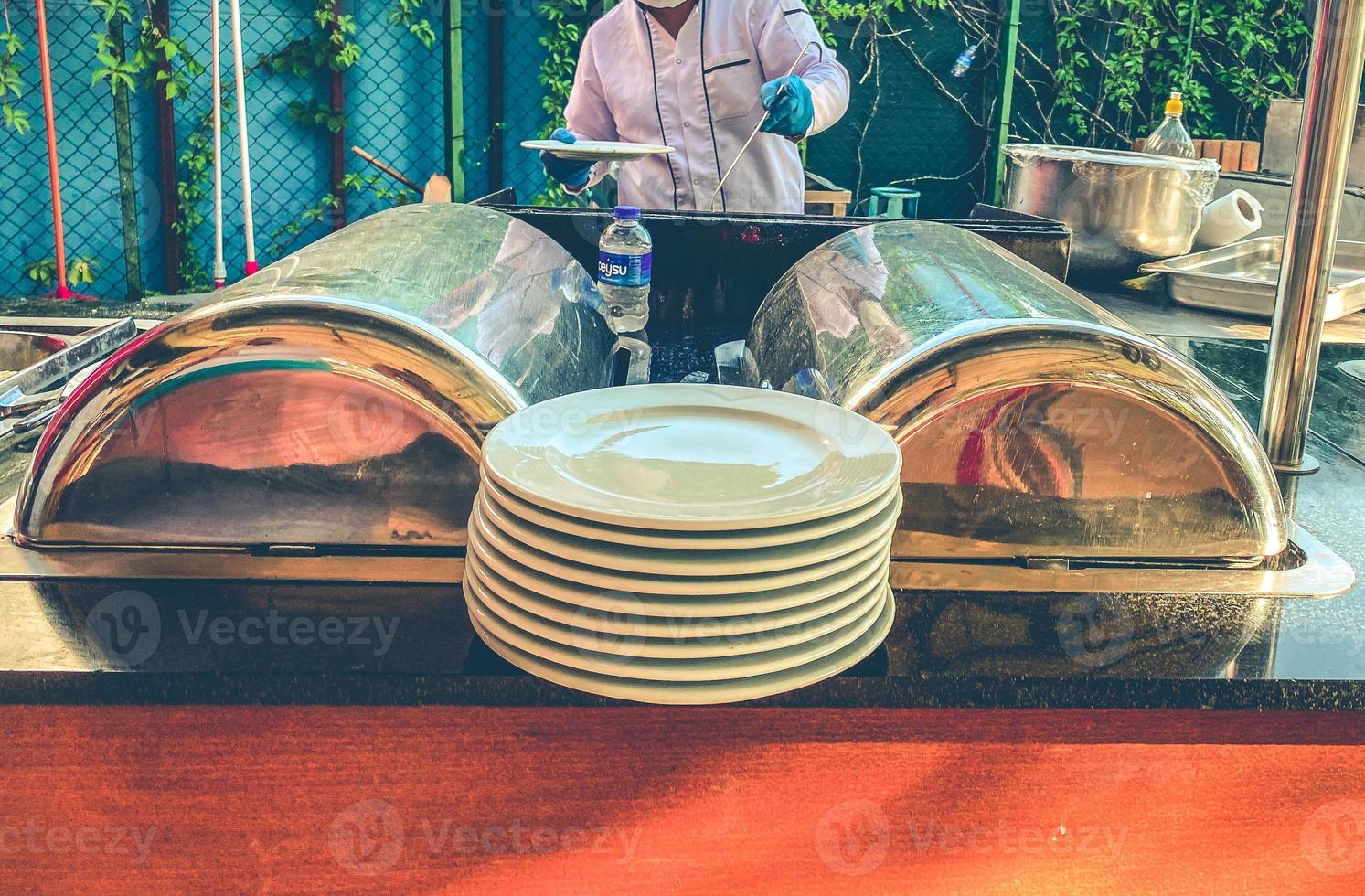 plates with dishes for lunch are laid on top. food dishes under a metal lid. protection of food from cooling and ingress of bacteria and germs photo