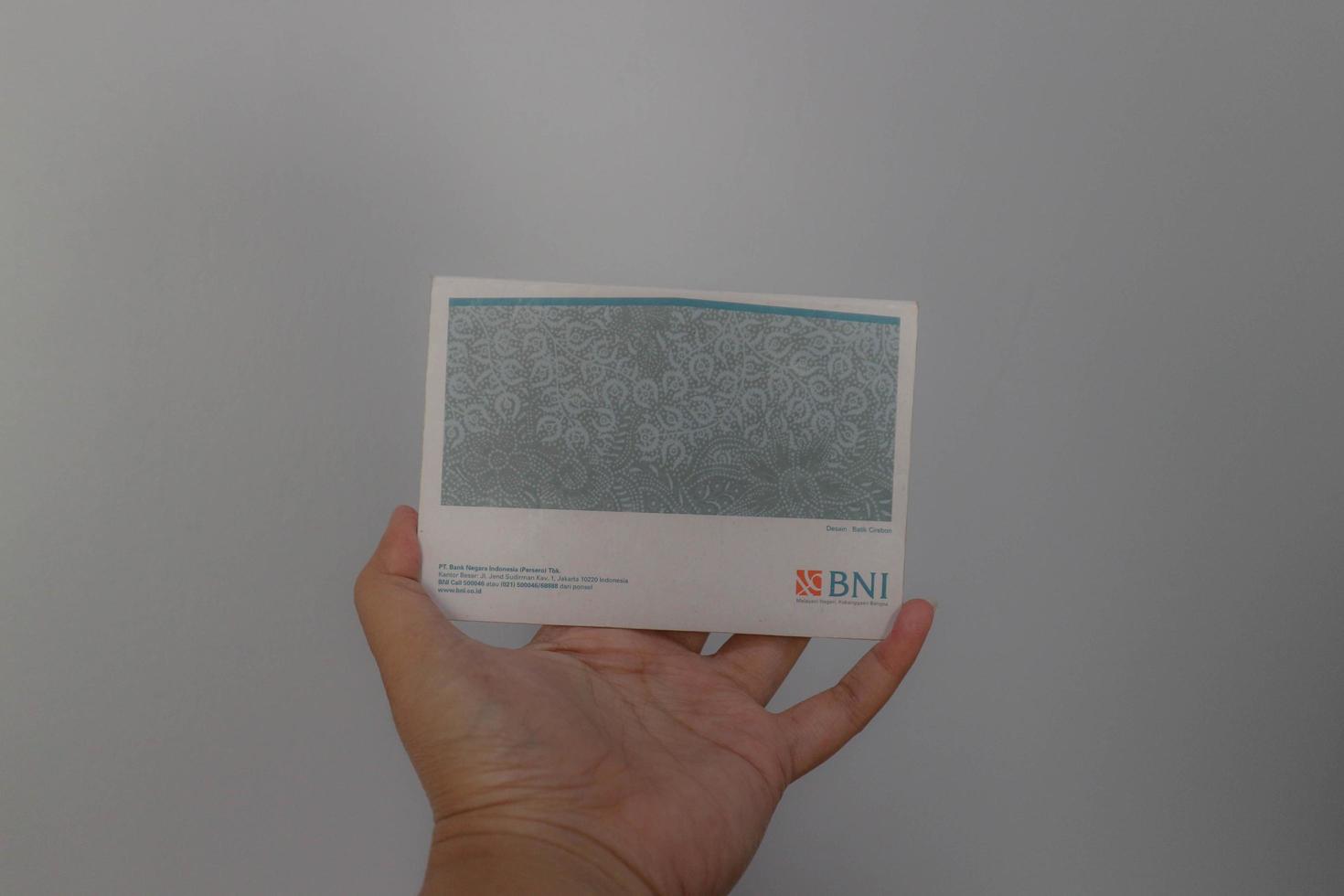 West Java, Indonesia on July 2022. A hand is holding a Bank National Indonesia account book. photo