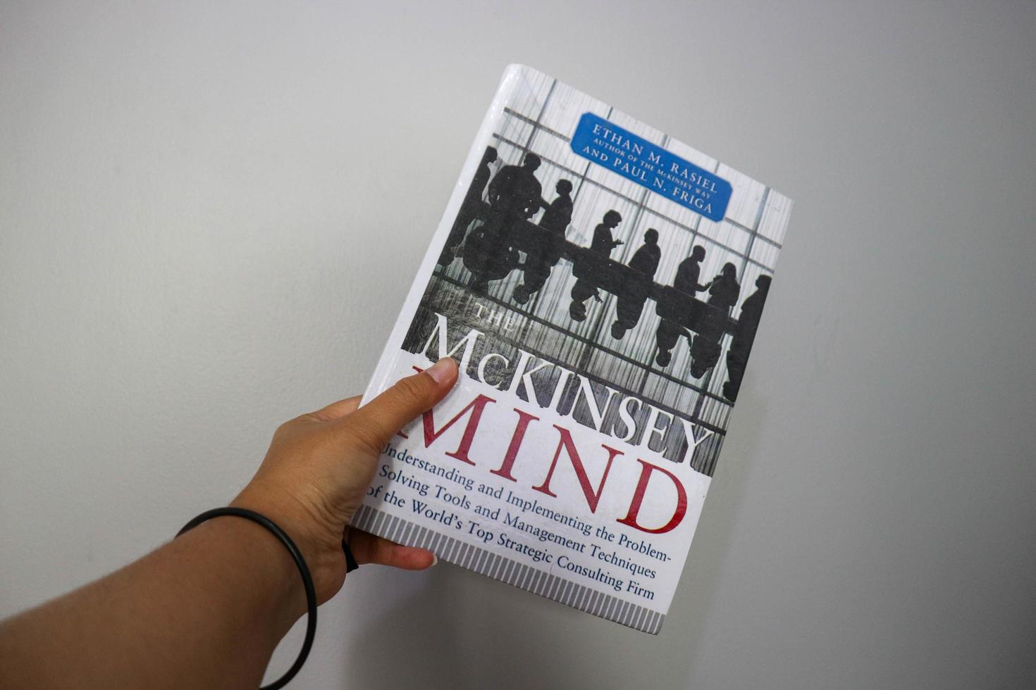 West Java, Indonesia on October 2022. A hand is holding a best selling book entitled Mc Kinsey Mind by Ethan M Rasiel photo