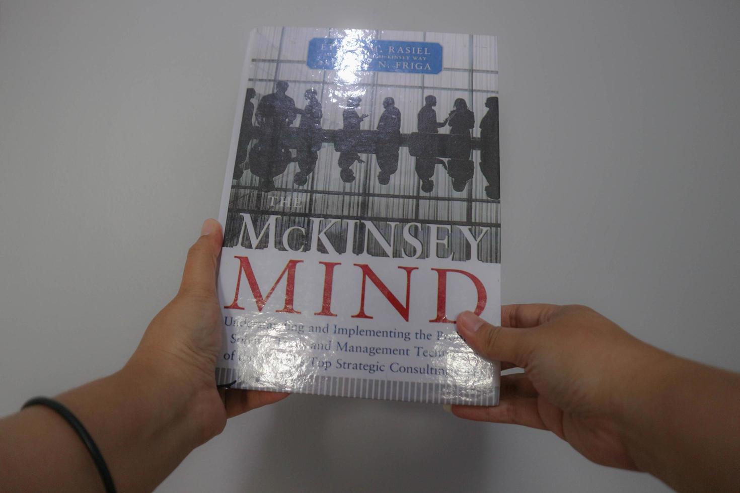 West Java, Indonesia on October 2022. A hand is holding a best selling book entitled Mc Kinsey Mind by Ethan M Rasiel photo