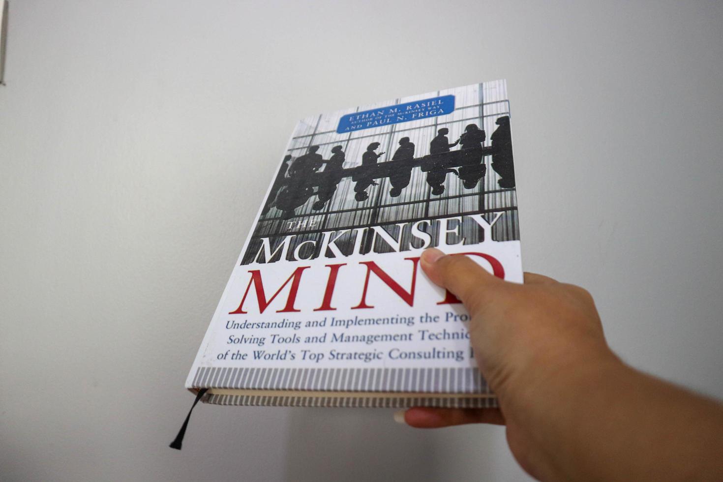 West Java, Indonesia on October 2022. A hand is holding a best selling book entitled Mc Kinsey Mind by Ethan M Rasiel photo
