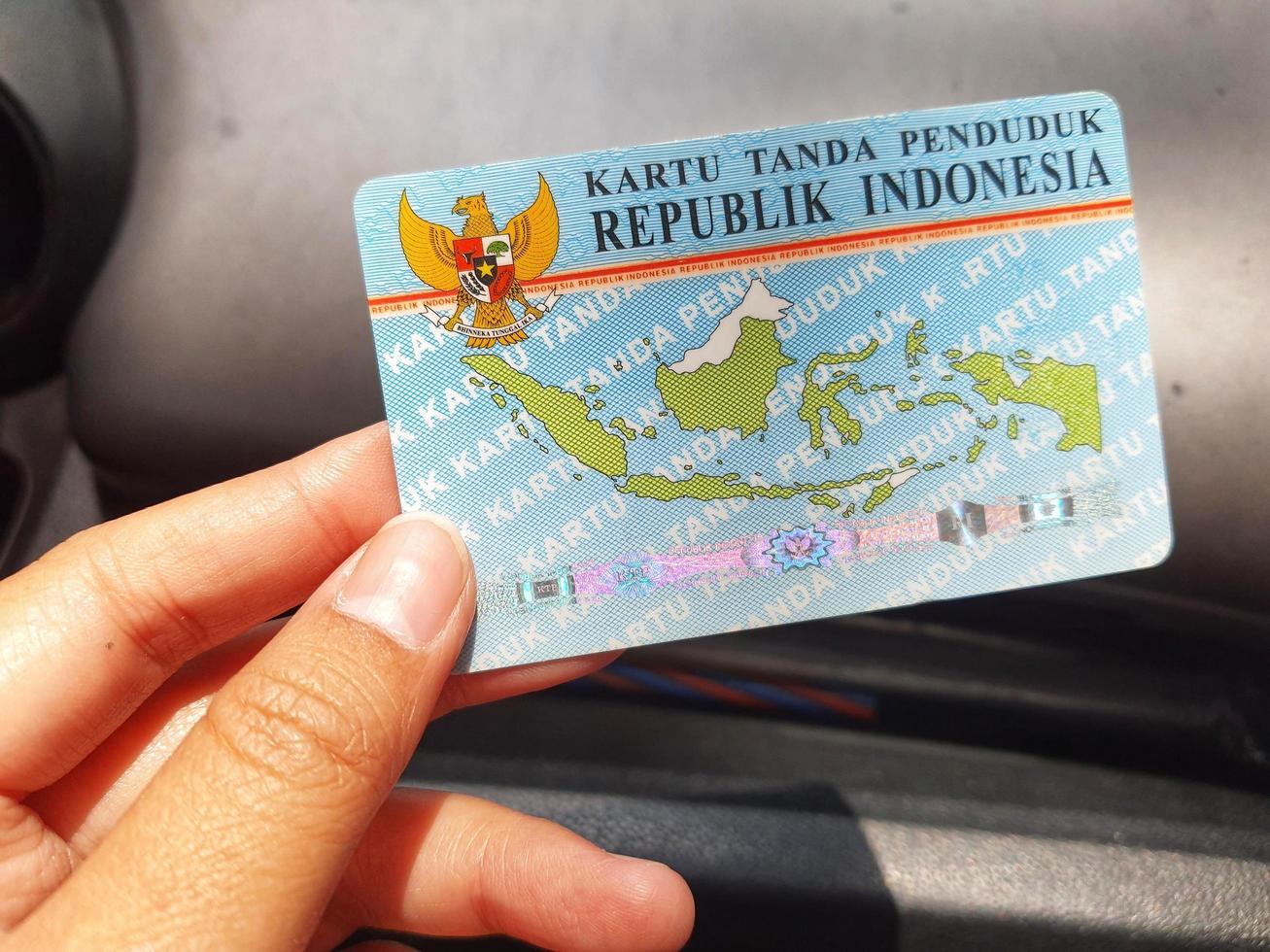 java central, indonesia en octubre de 2022. una mano sosteniendo una tarjeta de identificación. este ktp es emitido por el servicio de registro de residentes de indonesia. foto