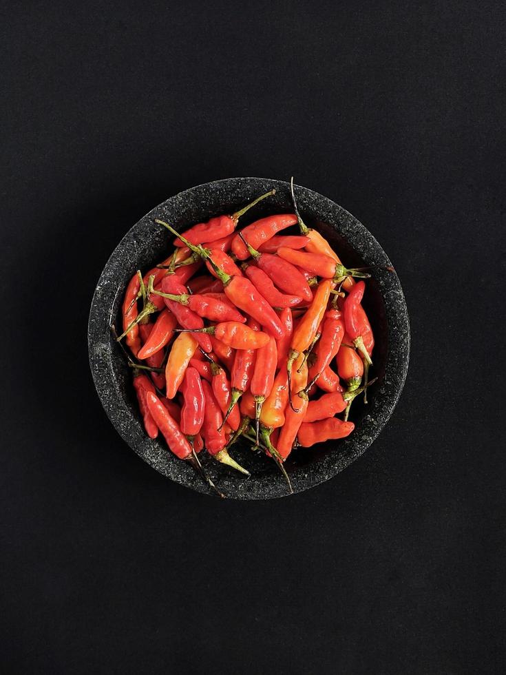 The spicy red birds eye chilies on the mortar photo
