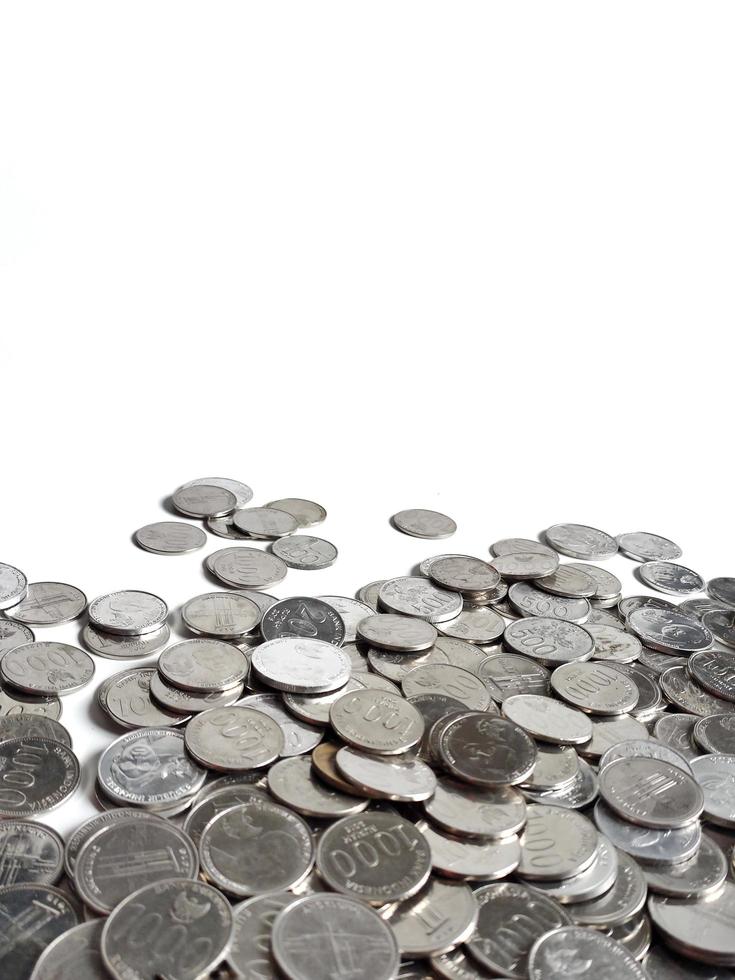 Scattered Indonesian's Rupiah coins on a white background with blank space for free text field photo