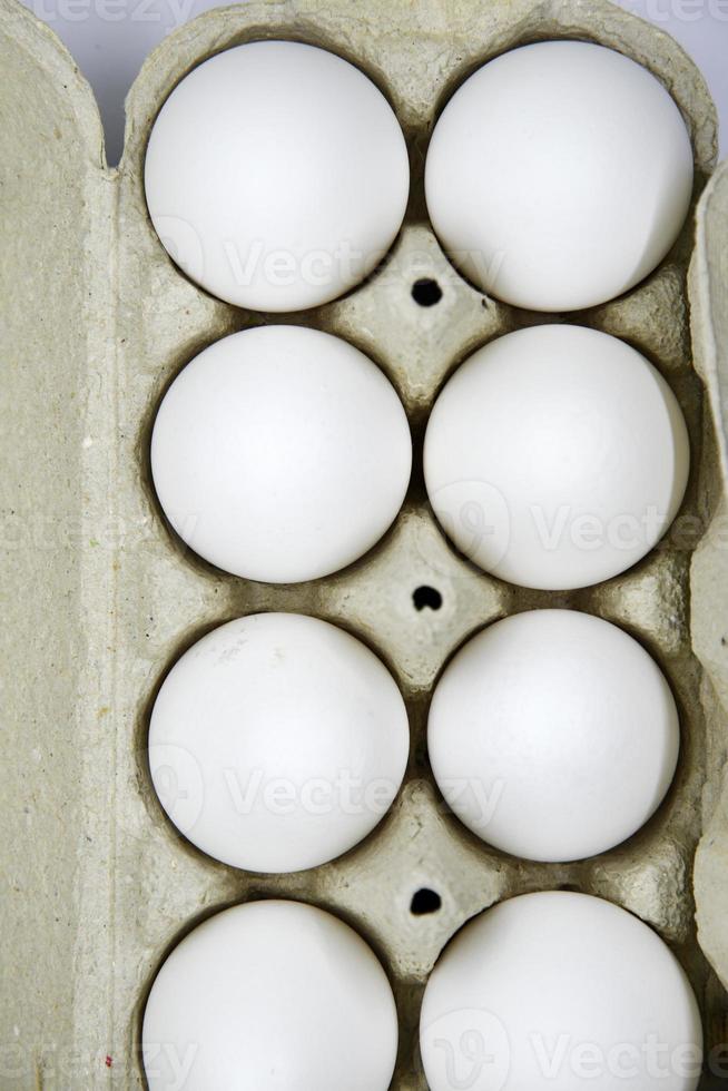 huevos de gallina blancos frescos en una bolsa de papel. huevos blancos en un paquete sobre un fondo blanco. huevos de la tienda. foto