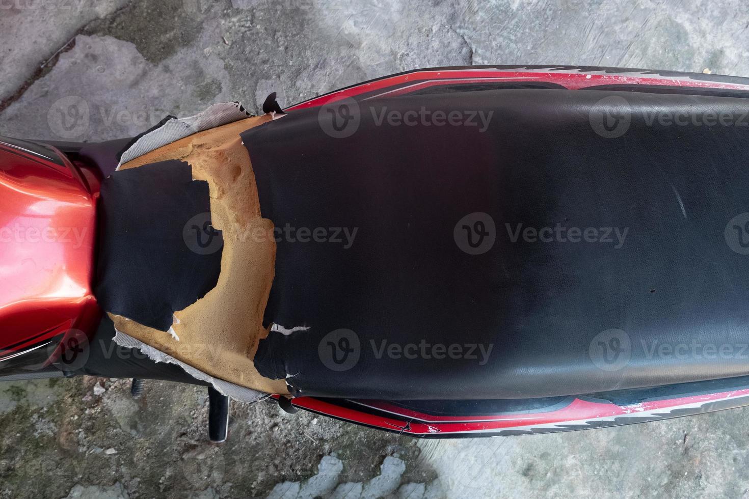 lacerated motorcycle seat , Old Black Leather seat is damage , Broken leather. photo