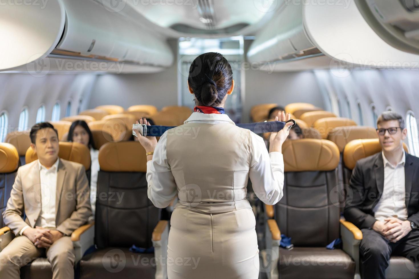 Asian flight attendant is demonstrating safety procedure using seat