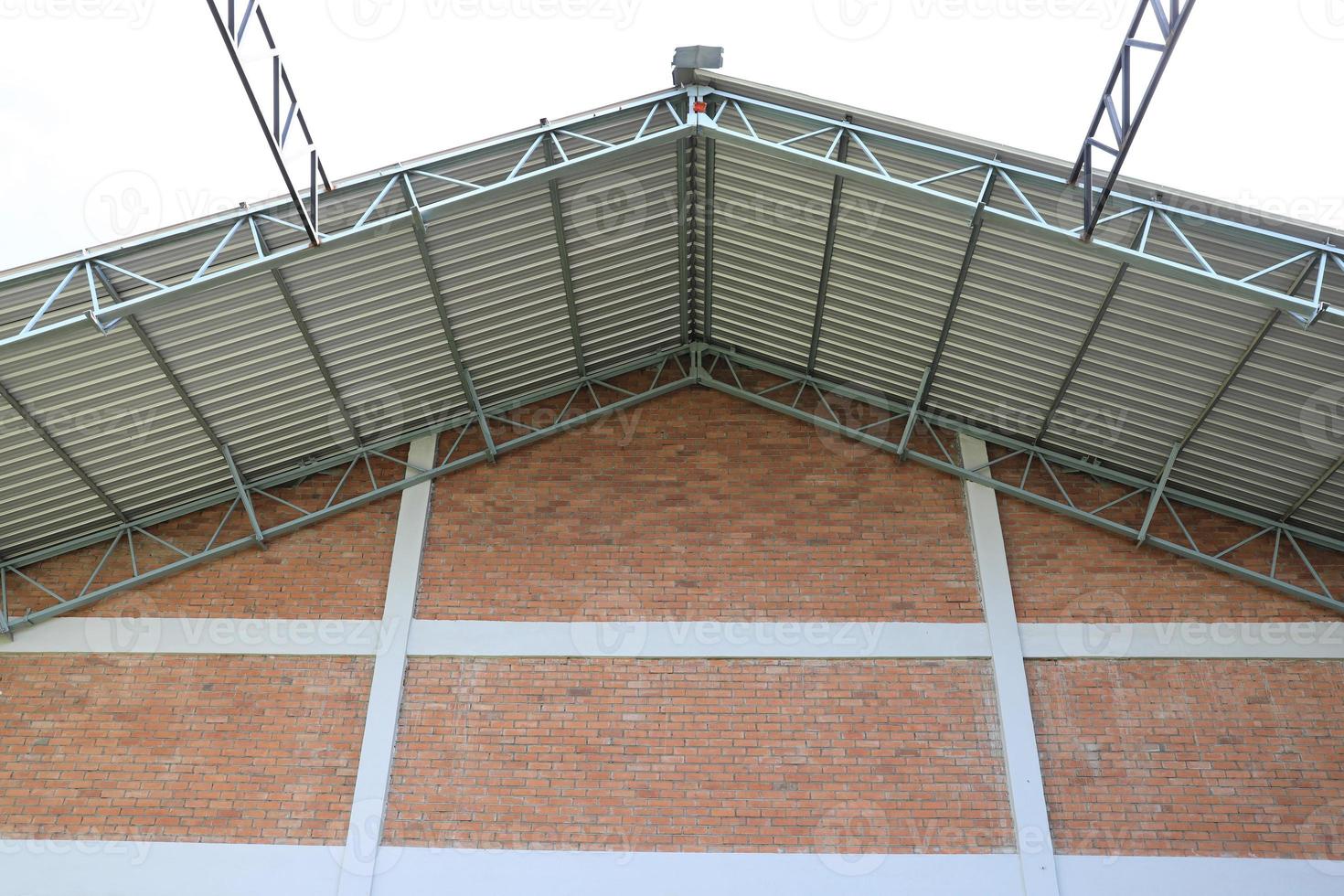 Warehouse roofing built on brick wall facade. photo