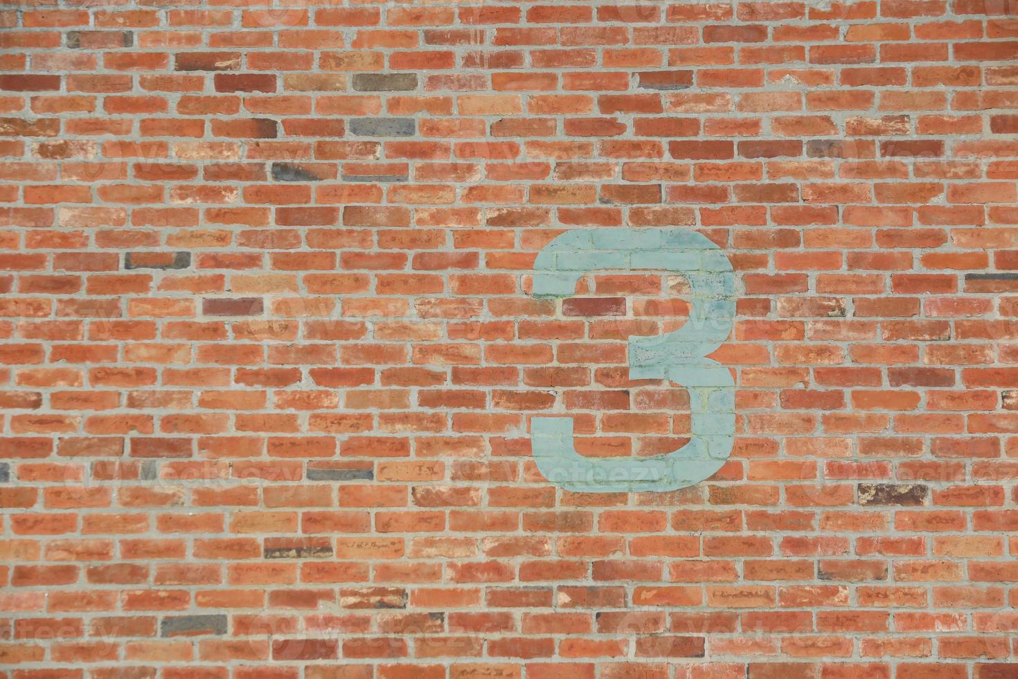 Number 3 painted on old brick wall. photo