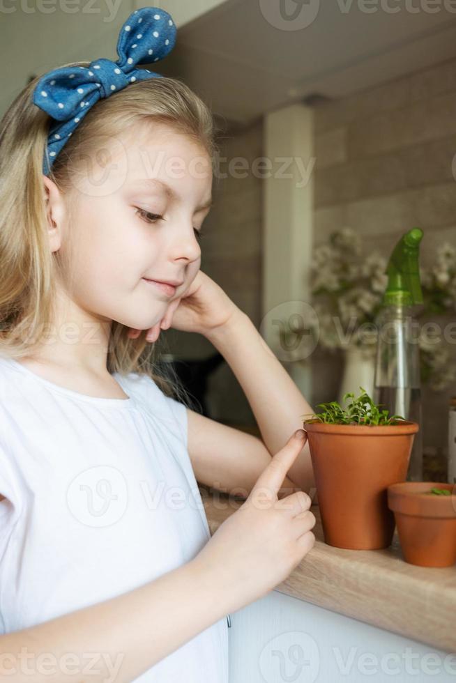 Little girl holding a pot of seedlings photo