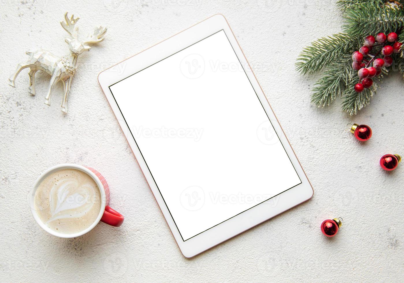 Christmas decorations and tablet on white concrete background. photo