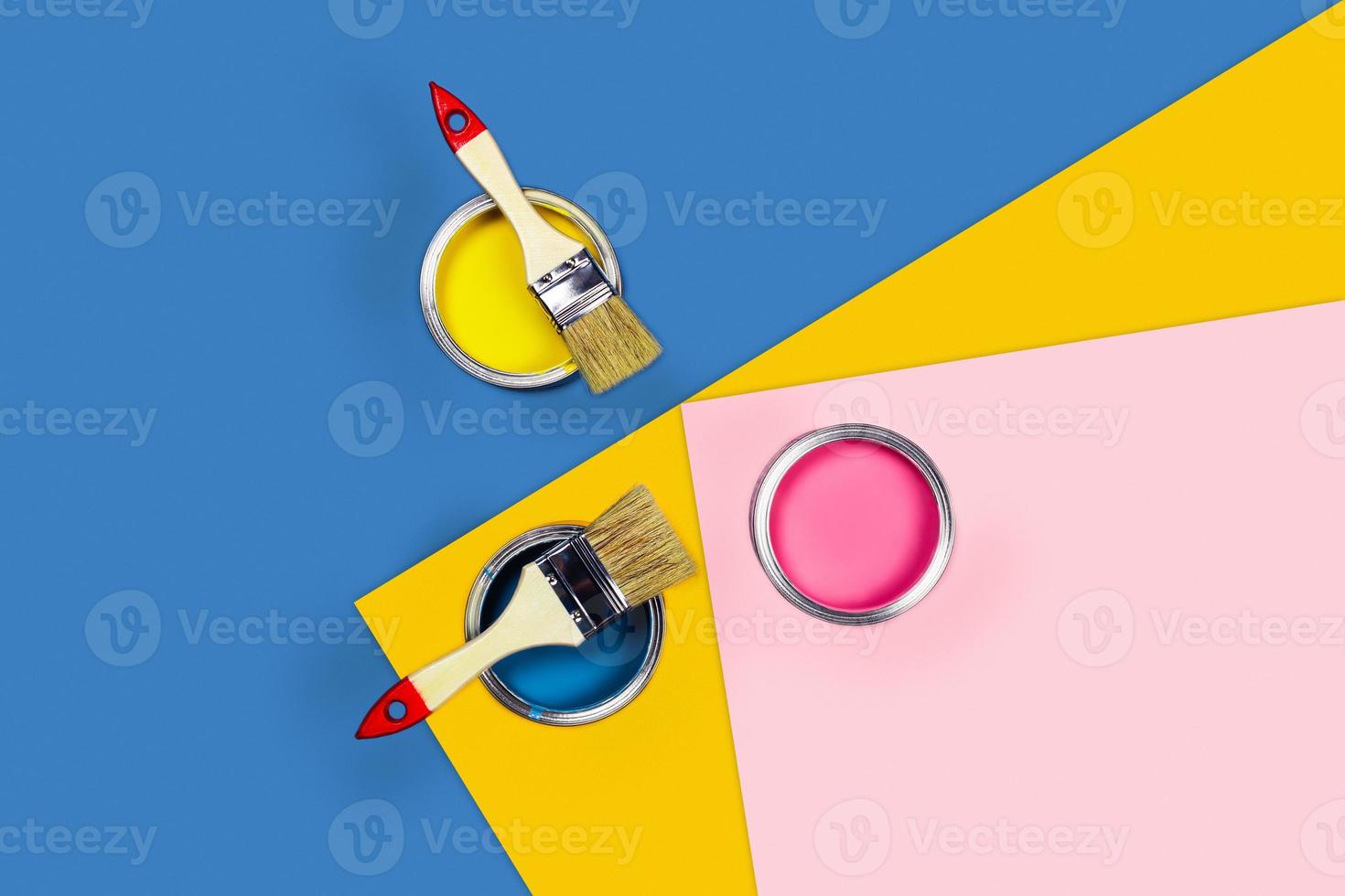 Three-colored background with paint jars and brushes. photo