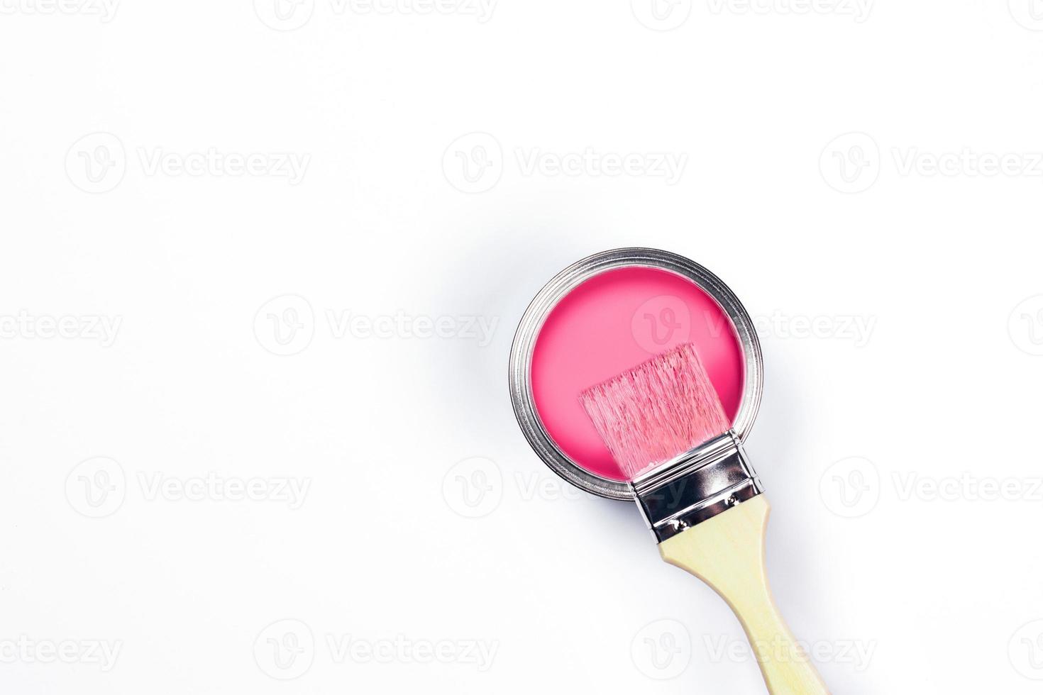 Two-toned background with pink paint jar and brushes. photo