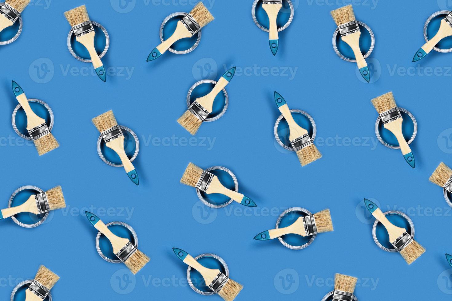 Blue background with paint jars and brushes on them. photo