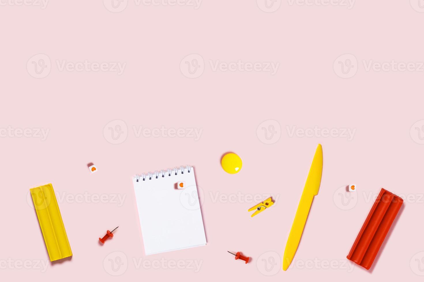Pink background with writing materials. photo