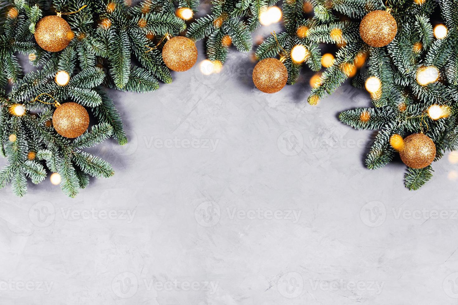 Christmas concrete background with fir tree and golden toys and lights. photo