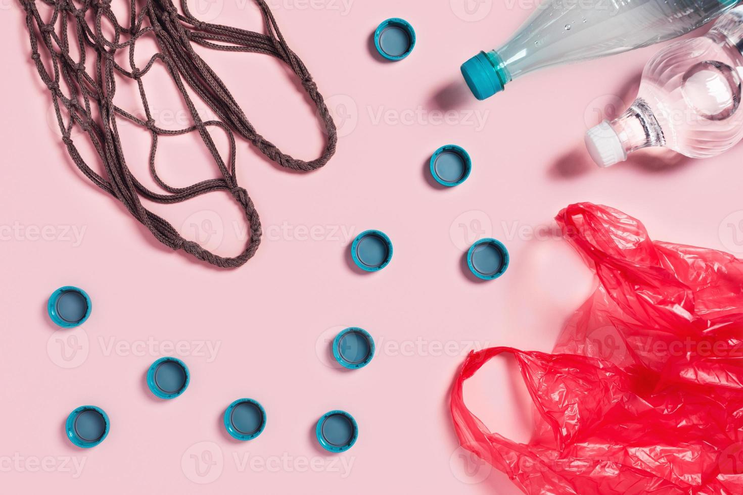 concepto de cero residuos. bolsa textil de malla con botellas de plástico, tazas y paquete. foto