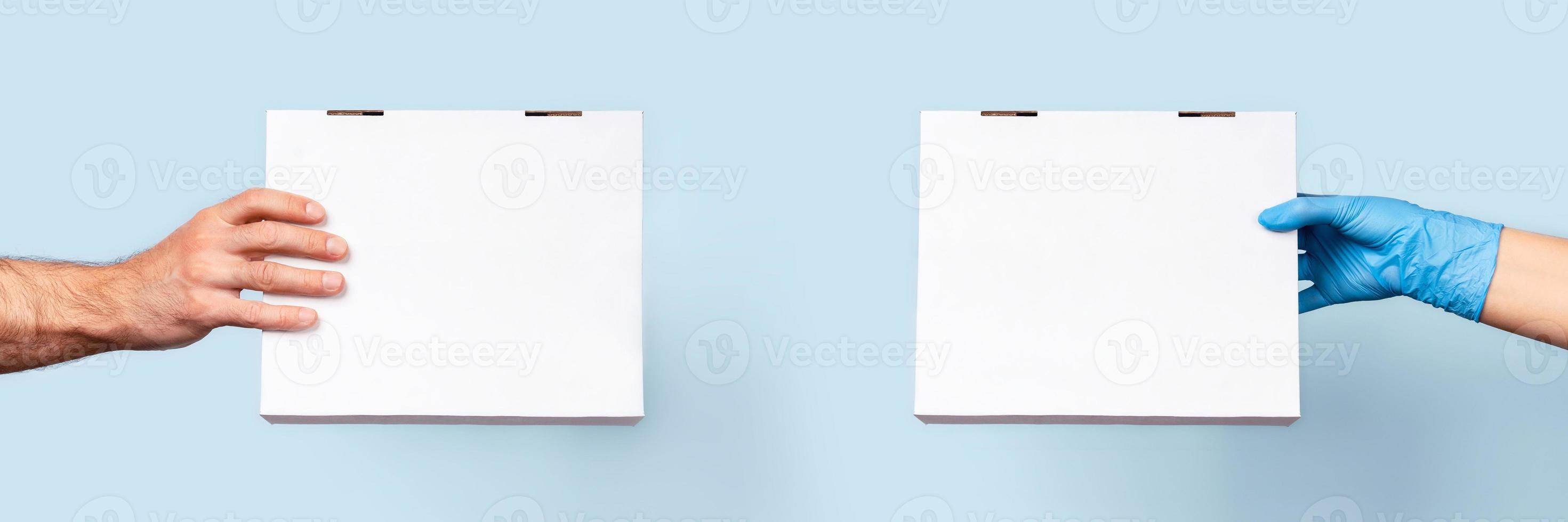 A blue background with two hands holding a boxes of food. photo