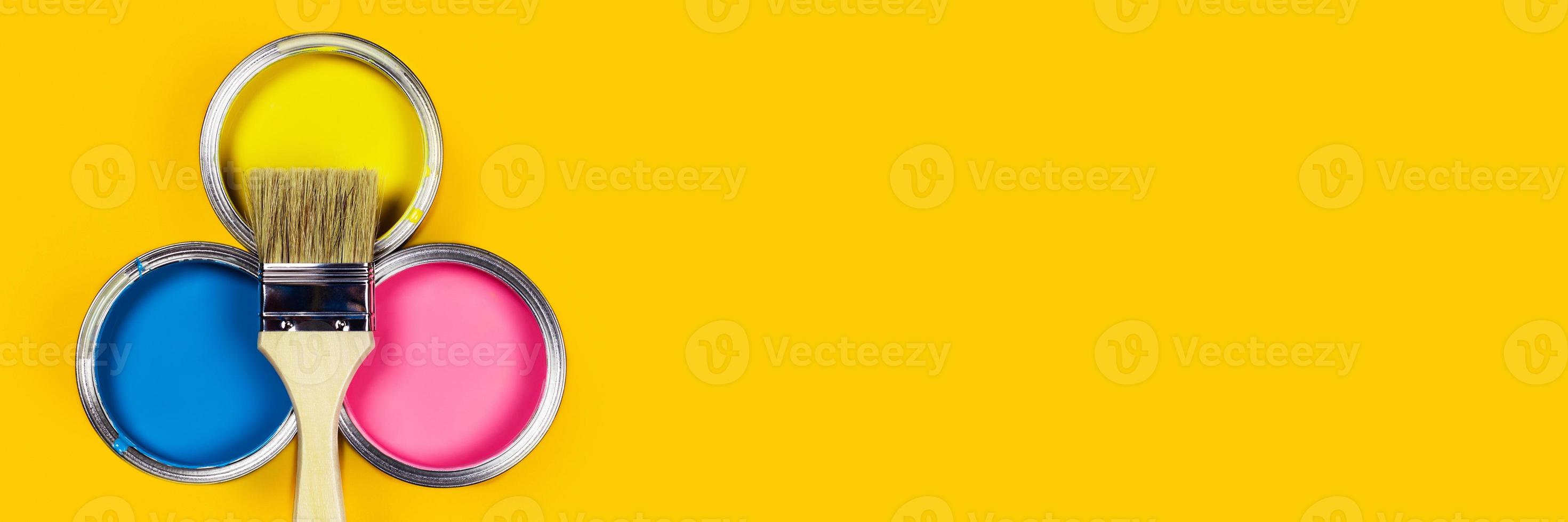 Colored background with paint jars and brush. photo