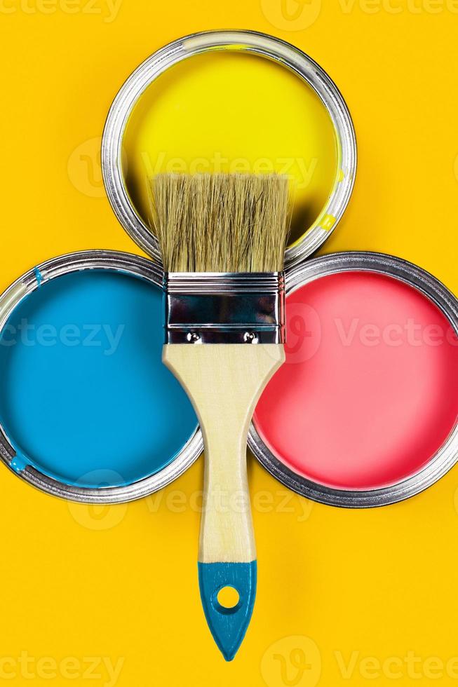 Colored background with paint jars and brush. photo