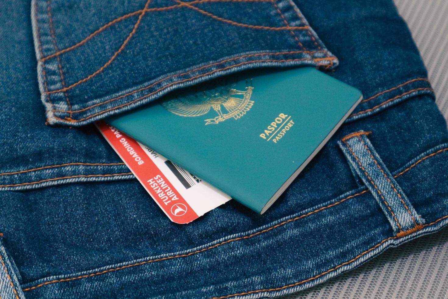 indonesia en julio de 2022. un pasaporte indonesio y una tarjeta de embarque de turkish airlines en un bolsillo de jeans. foto