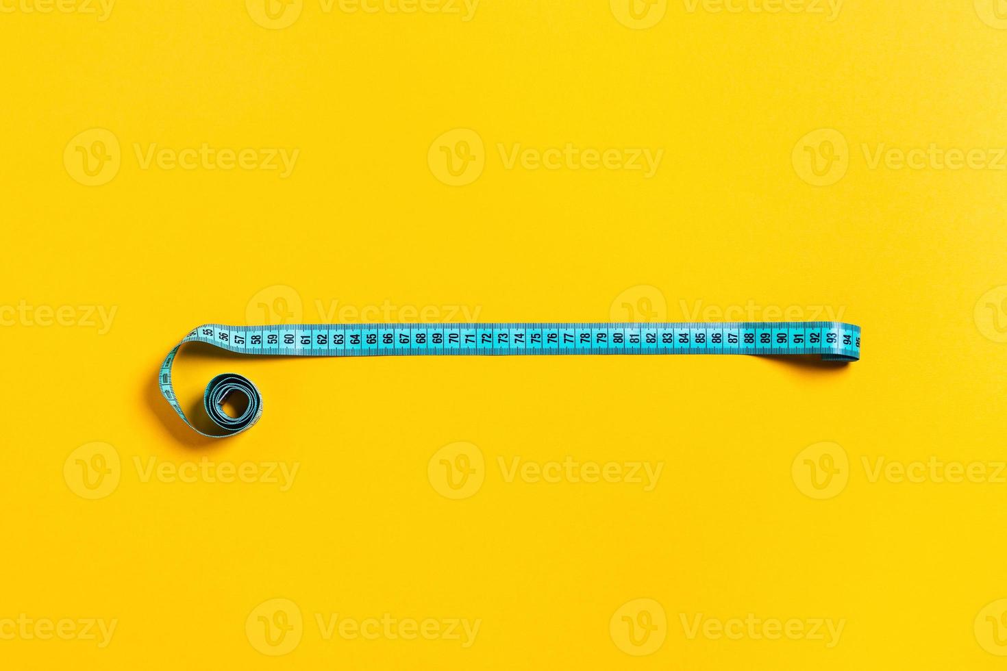Diet concept, tape measure on yellow background. photo