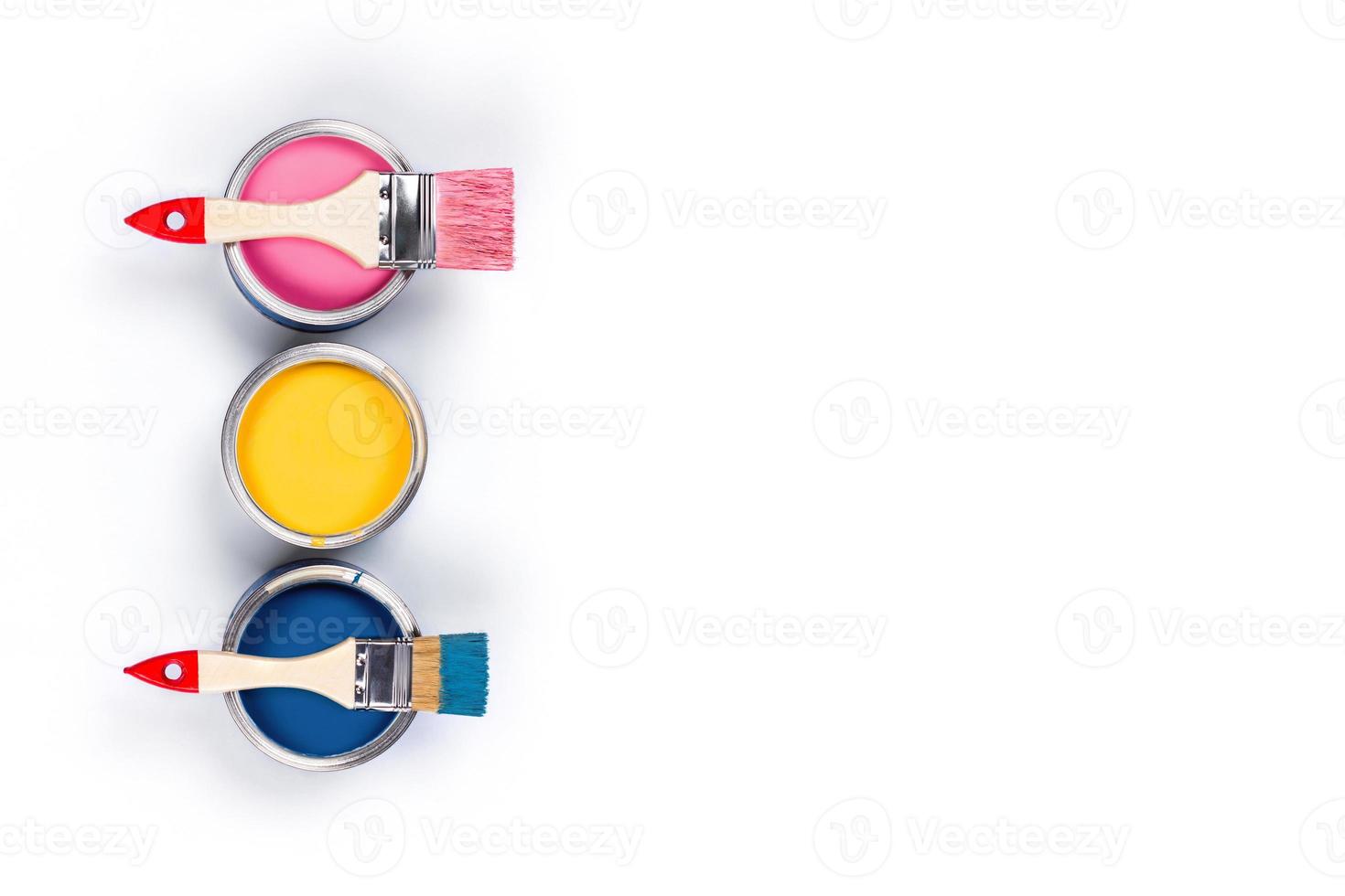 White background with three colored paint jars and brushes. photo