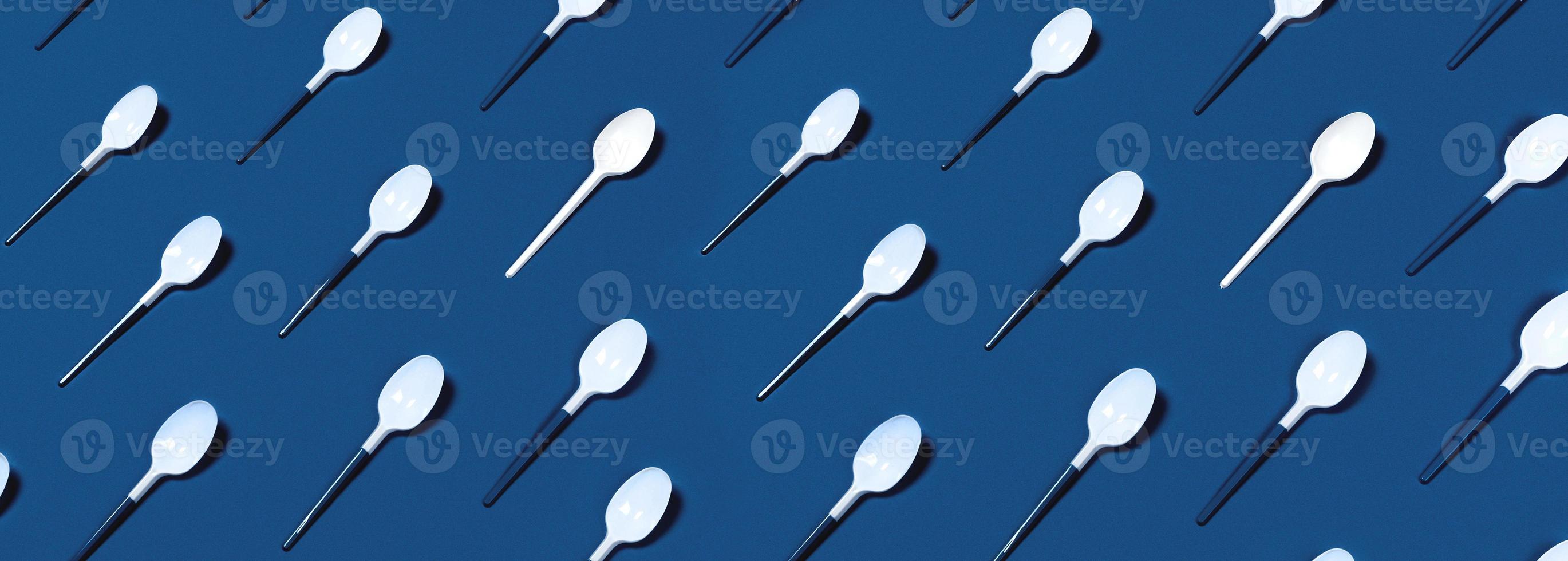 Pattern of white spoons on blue background. photo