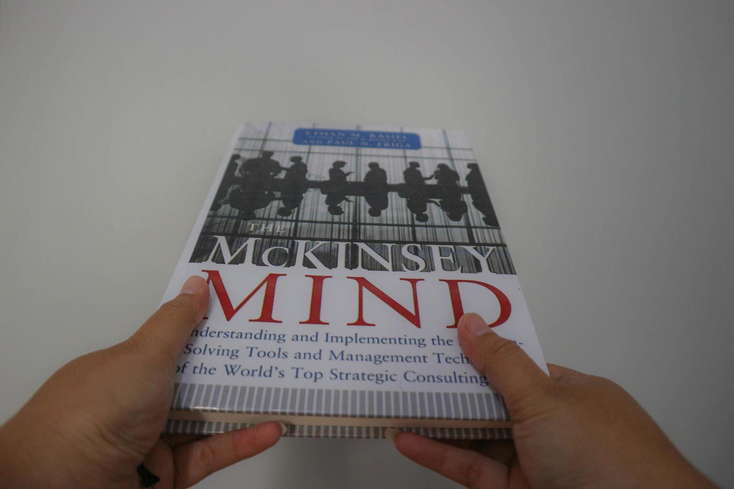 West Java, Indonesia on October 2022. A hand is holding a best selling book entitled Mc Kinsey Mind by Ethan M Rasiel photo